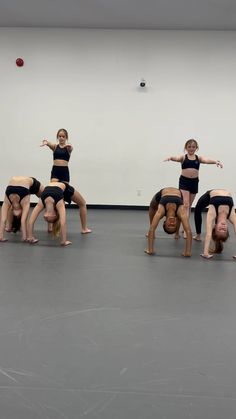 a group of young women standing on top of each other in front of a white wall