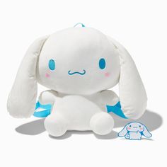 a white stuffed animal sitting next to a blue and white bunny toy on a white background