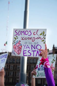 people holding up signs in spanish and english