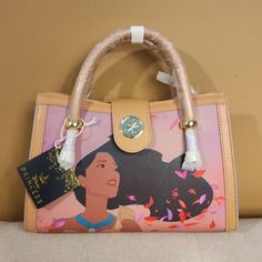 Enjoy Scenes From You Favorite Movie Pocahontas With This Sweet Handbag! Carry On Your Arm Or Wear As A Crossbody Bag. Make This The Perfect Gift For That Special Someone... Or Just Treat Yourself! * * * * Features * * * * * Height 7.5" * Width 3.5" * Length 11" * Dual Handle * Adjustable & Detachable Crossbody Strap * Gold Hardware * Flap With Magnetic Snap Closure * Faux Leather Exterior * Interior Is Tan Pocahontas Print Fabric * Inside Has 1 Zip Pocket, 1 Pouch * By Loungefly & Disney * New Disney Satchel Bag For Everyday Use, Brown Disney Bags For Everyday Use, Disney Style Brown Bag For Everyday Use, Disney Everyday Brown Bags, Disney Style Crossbody Bag For Daily Use, Disney Shopping Bags, Disney Brown Travel Bags, Disney Style Brown Travel Bag, Disney Style Shoulder Bag For Daily Use