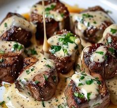 a white plate topped with meat covered in gravy