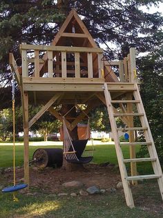 a wooden tree house with a ladder to the top