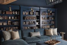 a living room filled with blue couches and bookshelves