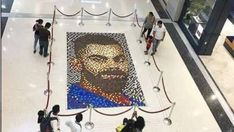 people are standing in front of a mosaic portrait of abraham lincoln at an airport lobby