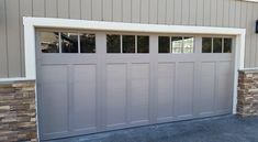 an image of a garage door that is painted light brown and has windows on each side