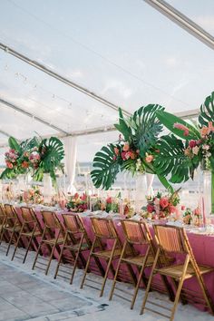 the tables are set up with pink linens and greenery