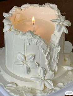 a close up of a cake with a candle in the middle and flowers on it