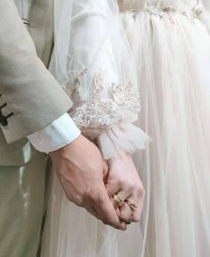 the bride and groom are holding hands