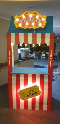 a red and white striped carnival booth with lights