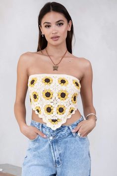 a woman wearing a crop top with sunflowers on it