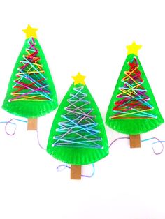 three christmas trees made out of construction paper and colored pencils are on the white background