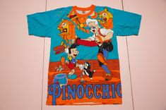 Vintage and rare PINOCCHIO aop all-over-print by Tony & Guy t-shirt. Made in Thailand. It is pre-used and in very good vintage condition. Size on label: Size fit men's M as medium. Please compare your measurements with the measurements provided below before buying this item.   Length from center back: 71 cm / 27.96" inches Chest: 50 cm / 19.69" inches Sleeve Length, from arm opening: 22 cm / 8.66" inches Shoulder to shoulder: 47 cm / 18.50" inches Material: 100% cotton. Condition: very good vint Vintage Cotton T-shirt With All Over Print, Multicolor All Over Print Crew Neck T-shirt, Retro Cotton T-shirt With All Over Print, Graphic Tee With All Over Print For Fans, Vintage Short Sleeve T-shirt With All Over Print, Pop Culture Printed Short Sleeve T-shirt, Pop Culture Cotton Tops With All Over Print, Cotton Sublimation Design Shirt For Fan Merchandise, Cotton Pop Culture Tops With All Over Print