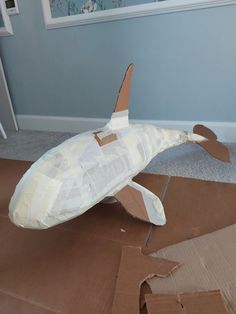 an airplane made out of cardboard sitting on the floor