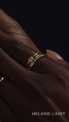 a woman's hand with two gold rings on her left and one diamond ring on her right