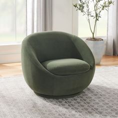 a green chair sitting on top of a rug next to a plant in a vase