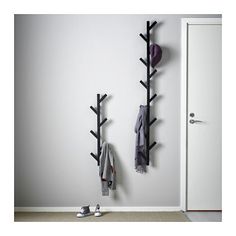 two coat racks with hats and scarves hang on the wall next to a door