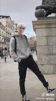 a young man standing next to a statue