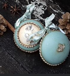 an old blue box with a bow on it sitting next to pine cones and other decorations