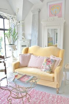 a living room filled with furniture and a pink rug on top of a carpeted floor