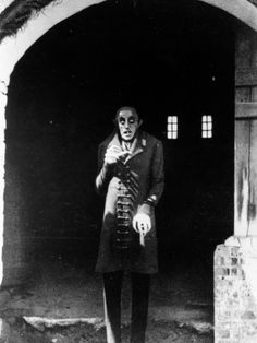 an old photo of a man standing in front of a tunnel with his hands on his hips