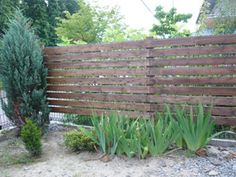 a wooden fence in the middle of a garden