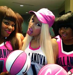 three girls in pink and white shirts holding volleyballs