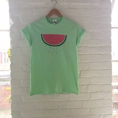 "Hand Printed and Hand Drawn! This is a 100% cotton screen printed t shirt with a hand drawn watermelon. It's perfect for summer! The shirt shown here is mint and is printed in red and green ink. If you are interested in a different color shirt, just message us and ask! // PROCESS: All of our items are individually hand printed by either me or my dad, which can lead to slight variations in placement. The ink is heat cured and will not fade over time. Since our items are printed to order, there i Green Fun T-shirt With Screen Print, Fun Green T-shirt With Screen Print, Cute Printed Green T-shirt, Cute Green Printed T-shirt, Summer Cotton Shirt With Fruit Print, Trendy Green T-shirt For Summer, Short Sleeve Cotton Shirt With Fruit Print, Fun Summer T-shirt With Screen Print, Cotton Shirt With Relaxed Fit And Fruit Print