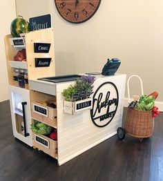 a display case filled with lots of vegetables and fruits next to a clock on the wall