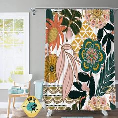 a shower curtain with colorful flowers and leaves on it in a white room next to a chair