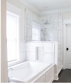 a white bathroom with a large tub and sink