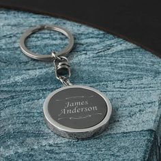 a personalized keychain is shown on a blue marble slab with the name james anderson