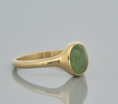 "14k solid gold Tourmaline ring. Oval cabochon green Tourmaline ring. This gold ring is a beautiful gift for your love. Classic Tourmaline ring. 14 k gold ring with beautiful green Tourmaline stone. An oval cabochon green Tourmaline stone set in a solid gold ring. This 14k solid gold ring has a beautiful presentation on the finger. The green Tourmaline stone is set vertical to the ring giving an illusion of a bigger stone. You going to love this tourmaline ring, specially if love the natural inc Oval Tourmaline Emerald Ring In Yellow Gold, Yellow Gold Emerald Ring, Oval Cabochon Gift, Yellow Gold Oval Cabochon Emerald Ring, Oval Cabochon Emerald Ring In Yellow Gold, Oval Tourmaline Emerald Ring With Bezel Setting, 14k Gold Oval Cabochon Emerald Ring Gift, Classic Oval Tourmaline Emerald Ring, Green Oval Cabochon Signet Ring As Gift, Green Oval Cabochon Signet Ring For Gift