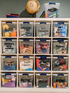 a shelf filled with lots of plastic bins next to a ball on top of a table