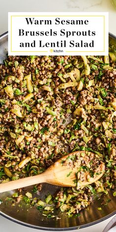 a skillet filled with cooked brussels sprouts and lentil salad next to a wooden spoon