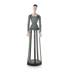 a wooden mannequin standing on top of a black stand