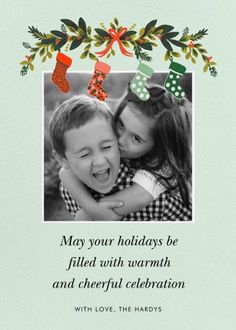 two children hugging each other in front of a christmas card