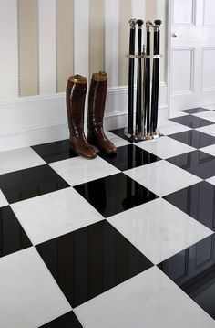 a pair of boots sitting on top of a black and white checkered floor