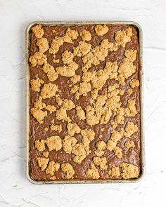 a pan filled with brownies and crumbs on top of a white table