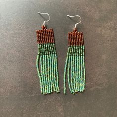 two pairs of beaded earrings on top of a table