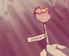 a hand holding a lollipop with an i love you stick attached to it