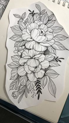 a drawing of flowers on paper next to a pencil and marker board with markers in it