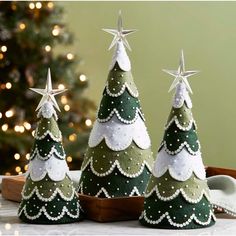 three small christmas trees sitting on top of a table