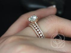 a woman's hand holding an engagement ring and wedding band with a diamond on it