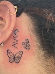 a woman's behind the ear tattoo with three butterflies on her left side, and an inscription that says wake