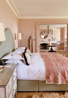 a bedroom with pink walls and white bedding