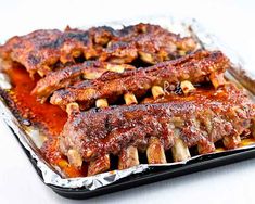 ribs covered in bbq sauce sitting on top of tin foil