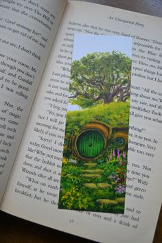 an open book with a green door in the middle and flowers growing out of it