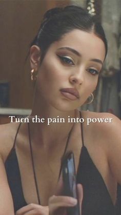 a woman holding a cell phone in her right hand with the caption turn the pain into power