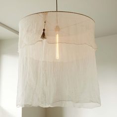 a white lamp hanging from a ceiling in a room