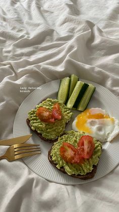 an open face sandwich topped with avocado and tomatoes